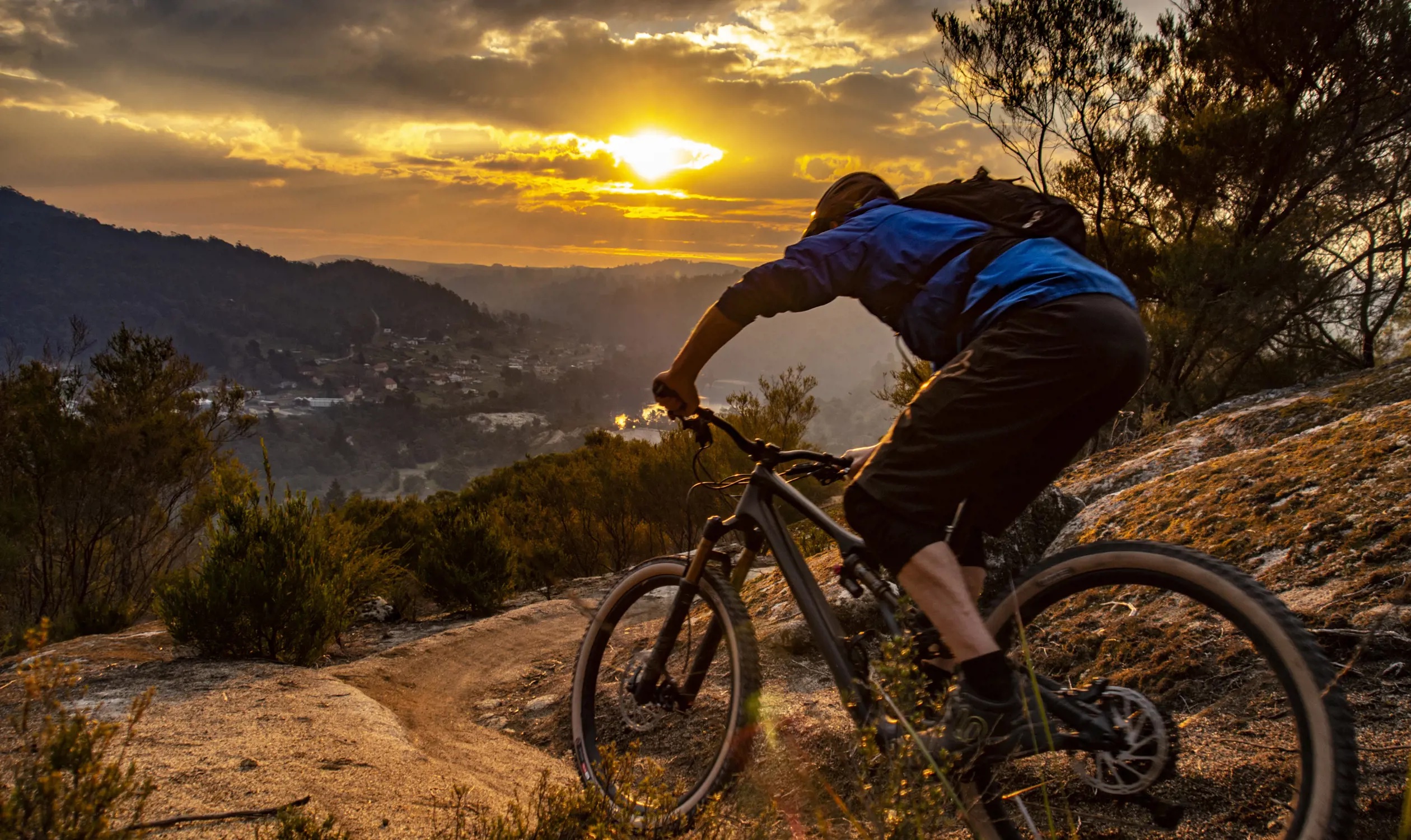 Mountain bike rider summitting a hill overlooking the town of Blue Derby